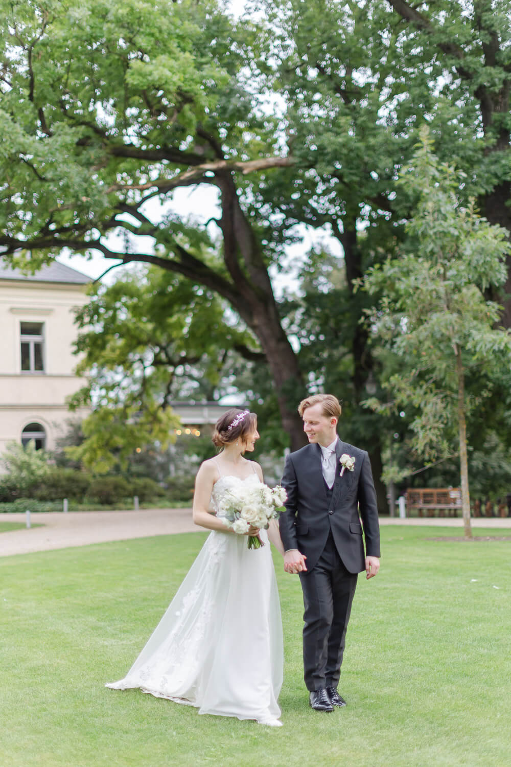 Prague Wedding Venue Mcely Destination Photographer Peter Rigo 183 Couple walking hand in hand through the park at Château Mcely