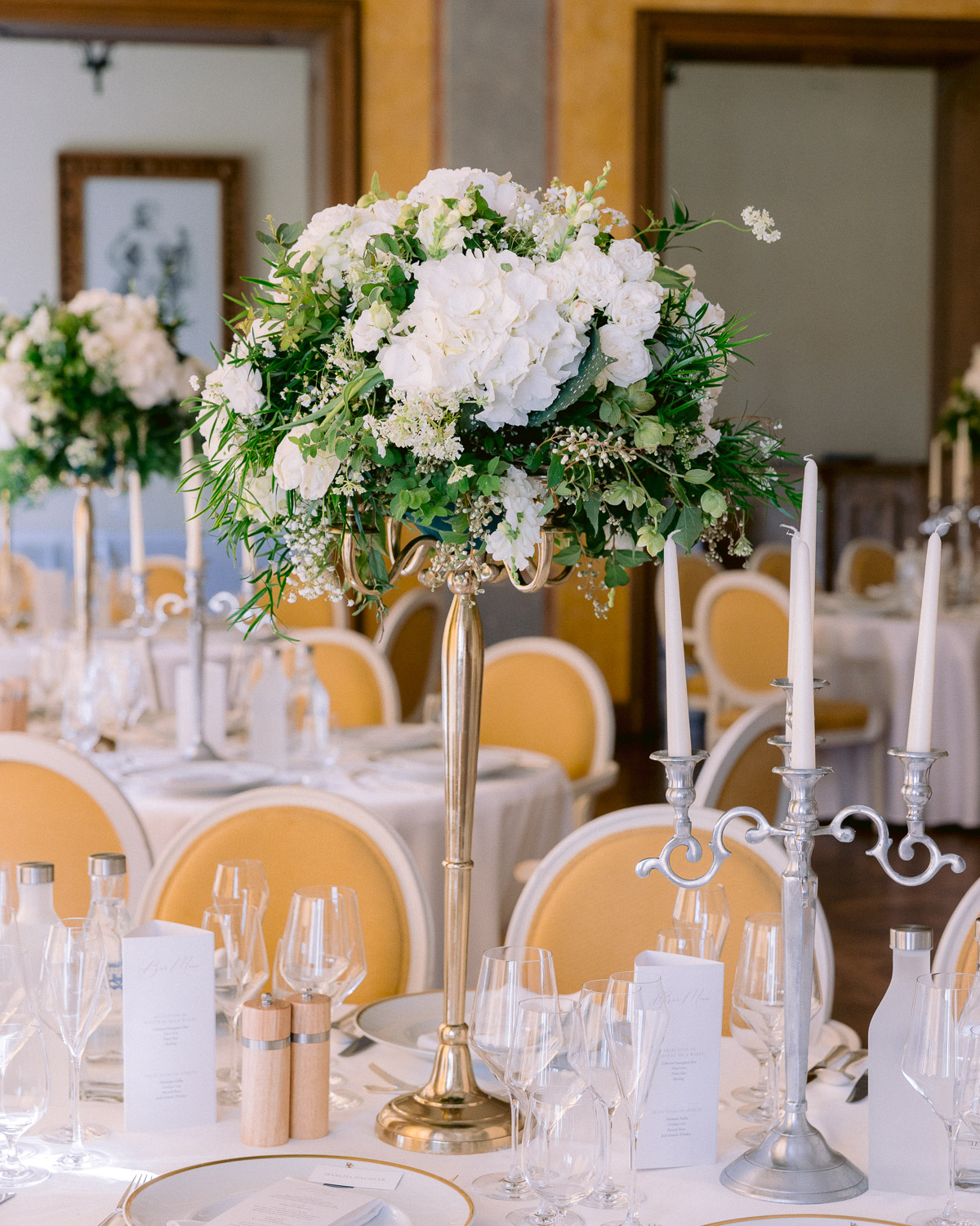Wedding reception tables set with white flowers and candles