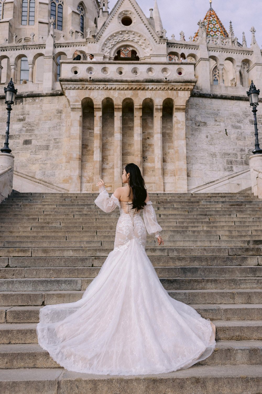 Bride with a long train on the stairs of Fisherman's Bastion, Budapest