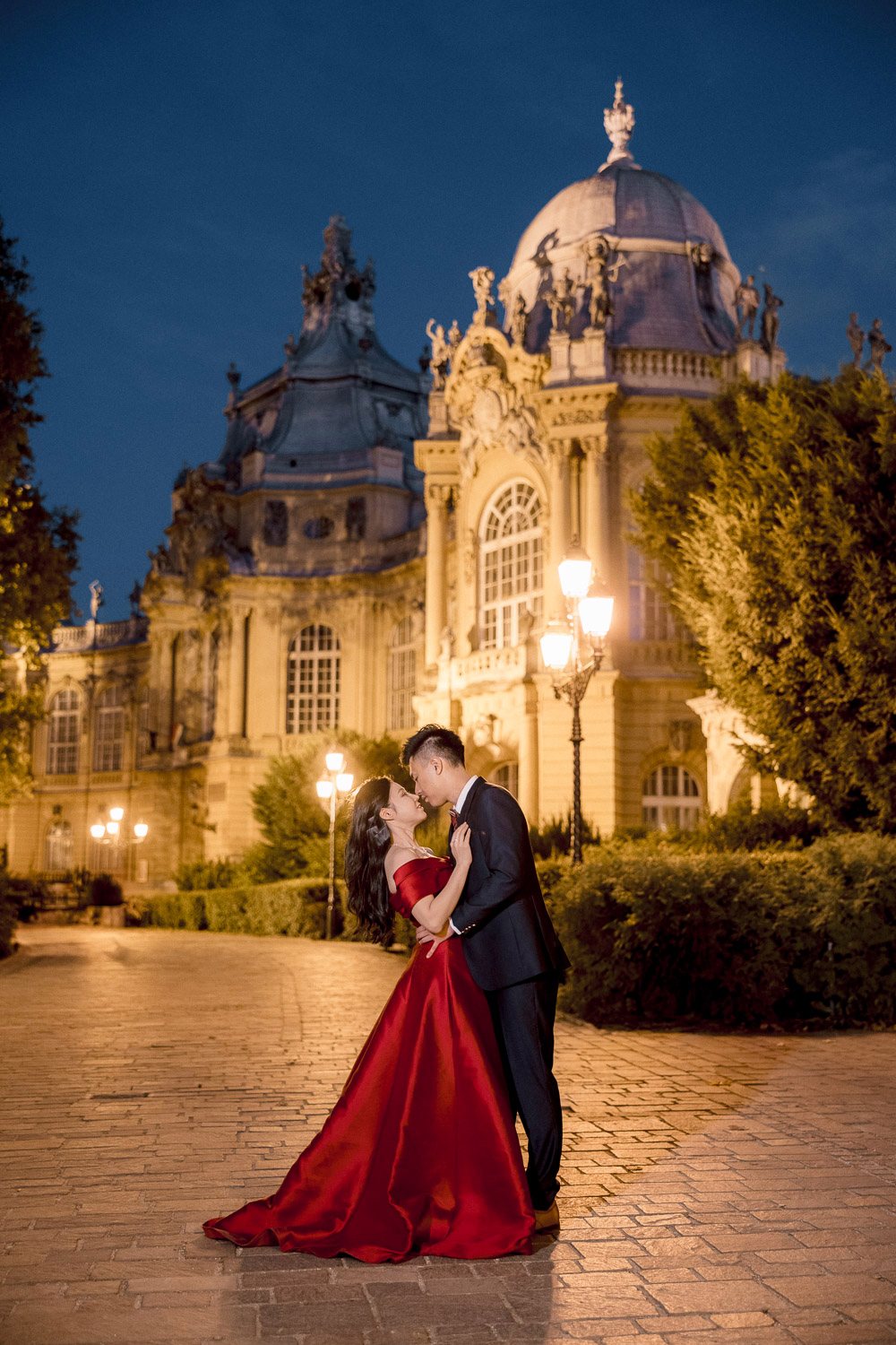 Bride in a red dress with the groom at night in Budapest