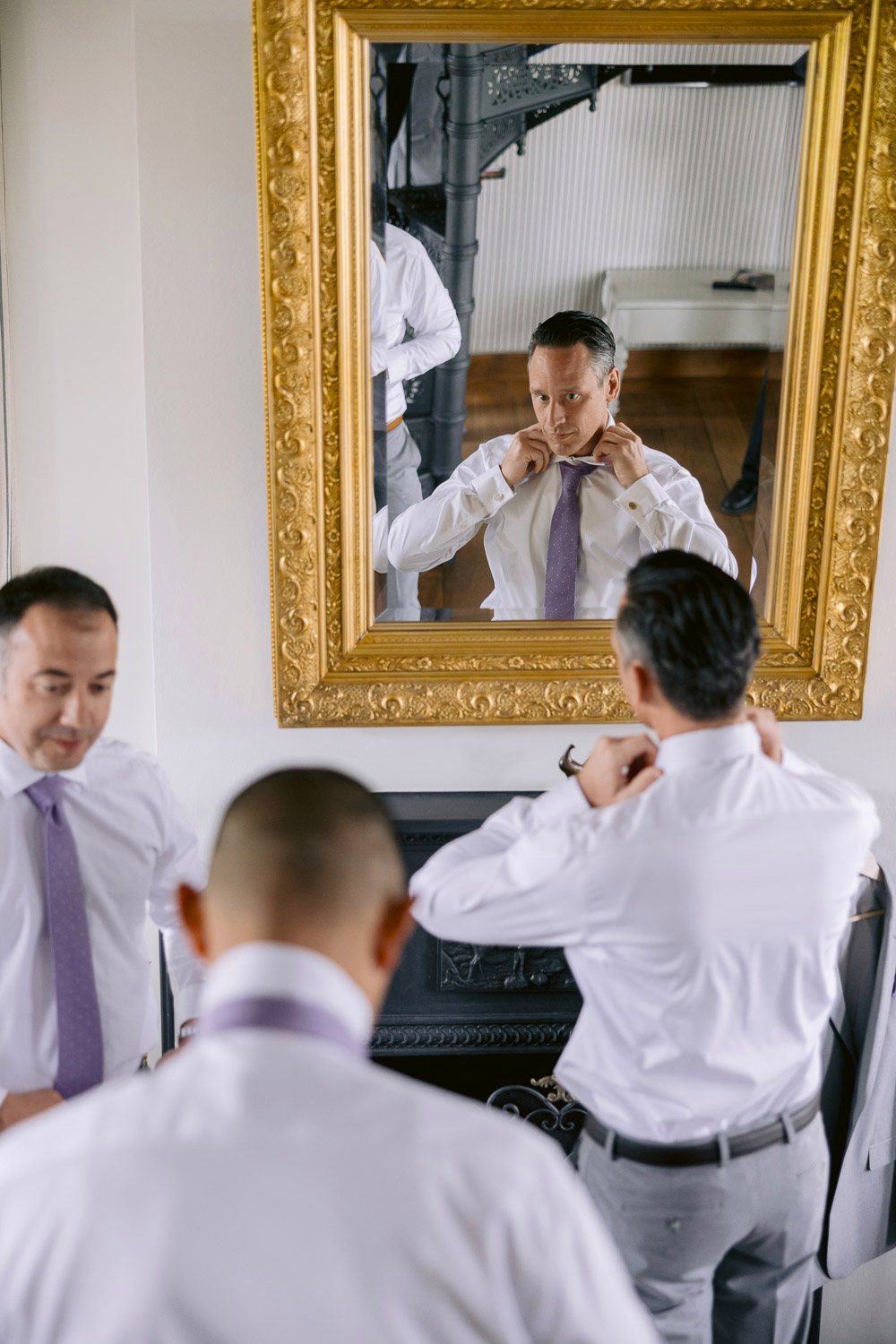 Chateau Mcely Groom Getting Ready Mirror Groom getting ready in front of a gilded mirror at Château Mcely