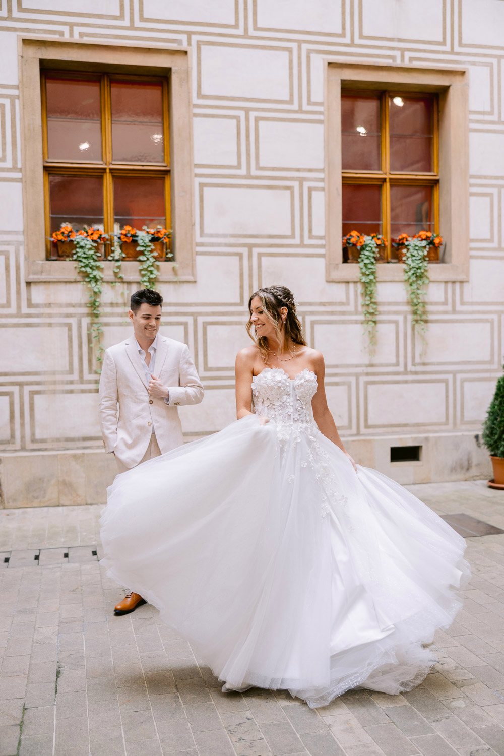 Lobkowicz Palace Elopement Bride Twirl Castle Courtyard Bride twirling her dress in front of the groom