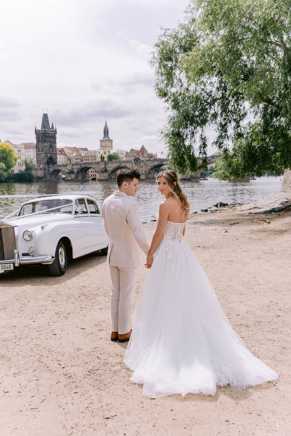 Lobkowicz Palace Elopement Couple Riverbank Rolls Royce Couple walking on the riverbank near the Rolls-Royce