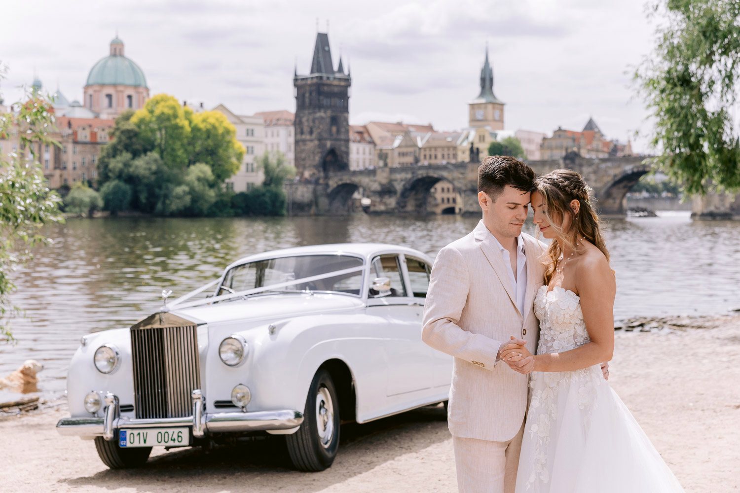 Lobkowicz Palace Elopement Couple Rolls Royce Charles Bridge View Newlyweds by the Rolls-Royce with Charles Bridge and the Old Town behind