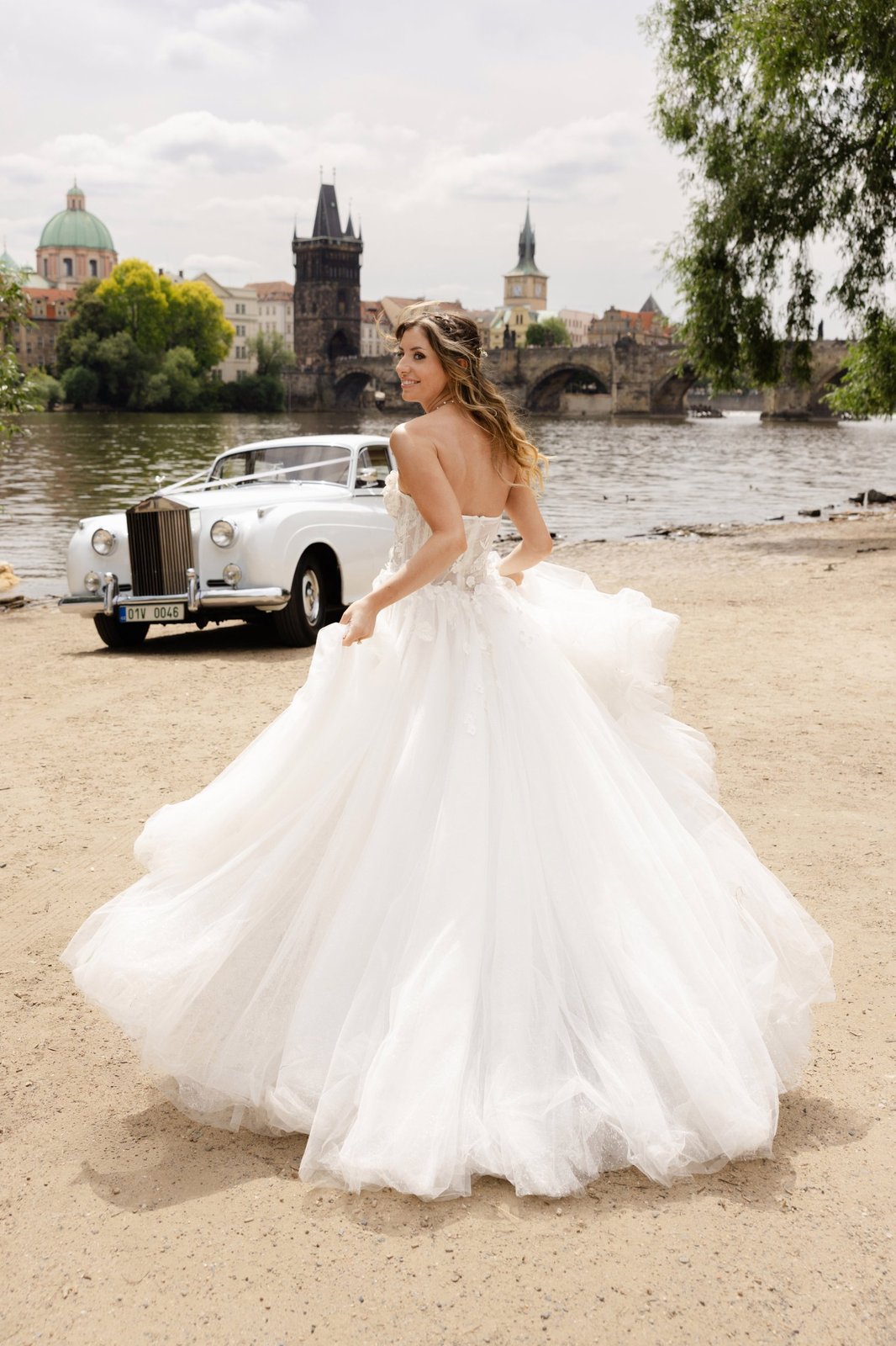 Prague-bride-twirl-rolls-royce Bride twirling by a vintage Rolls-Royce on the Vltava river
