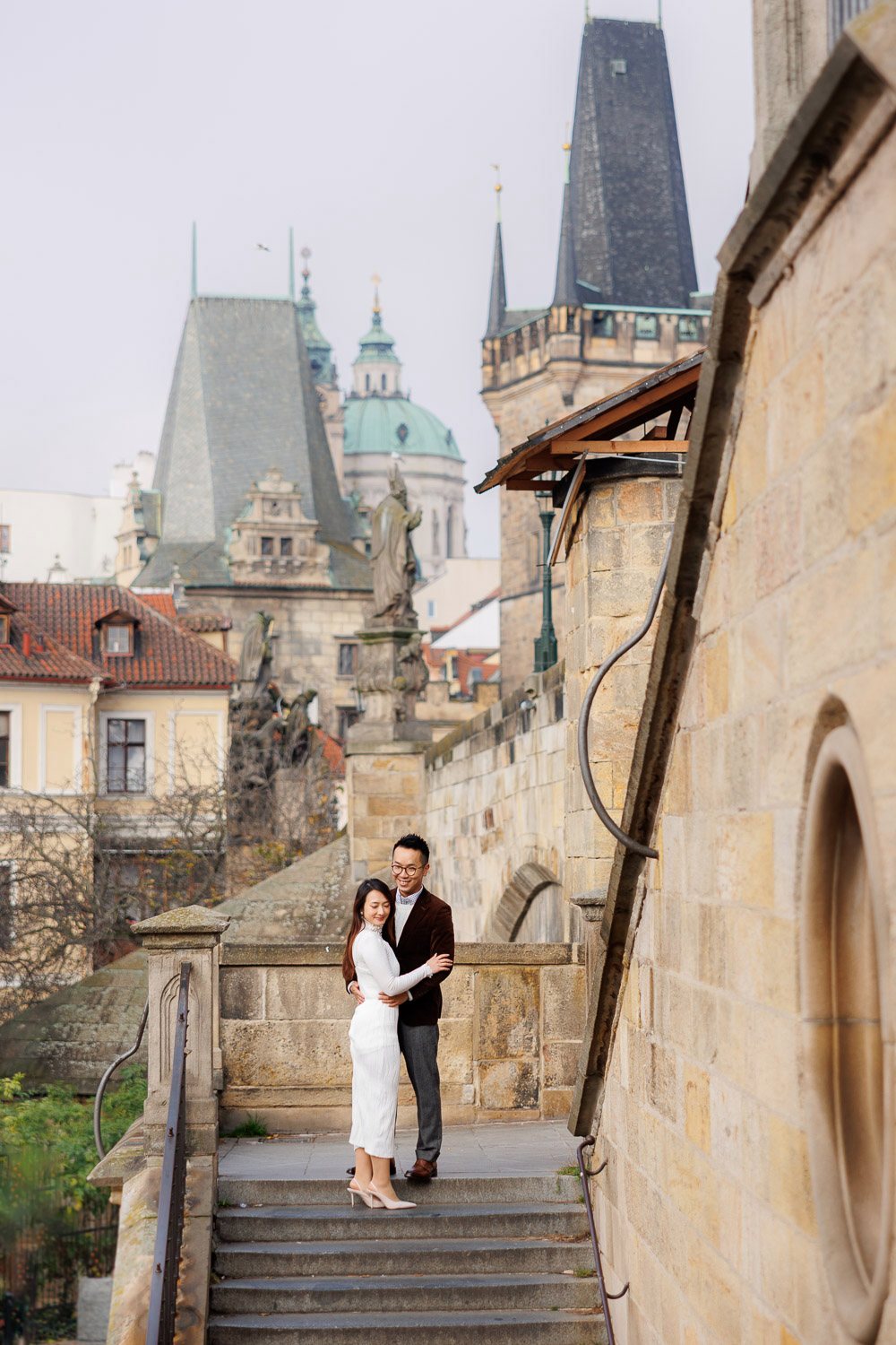 Couple walking down old stairs by the bridge tower