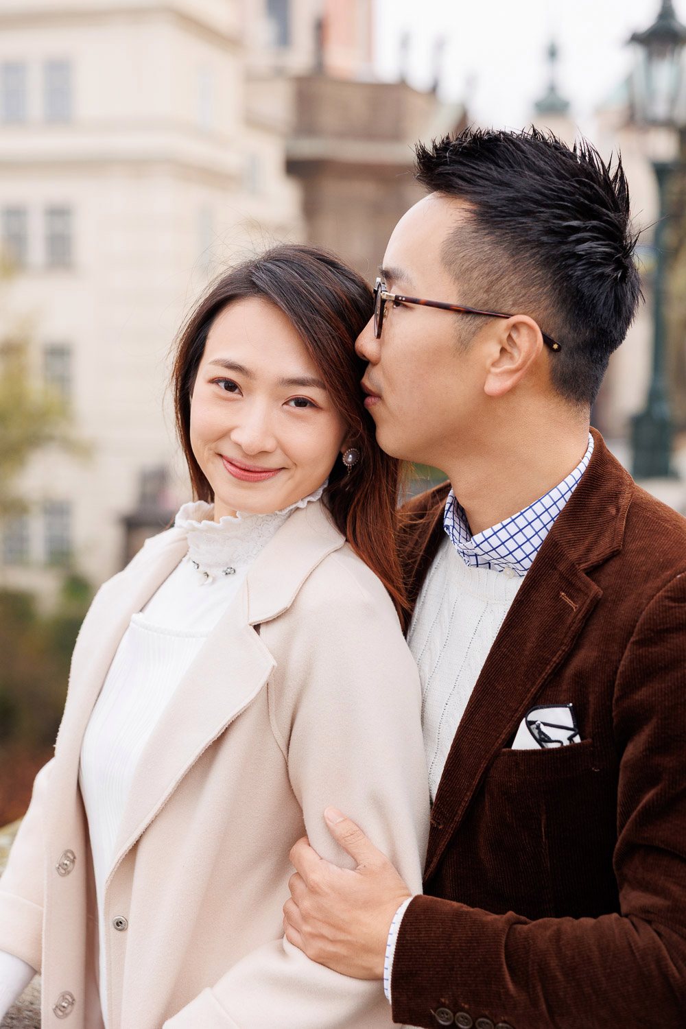 Couple smiling on Charles Bridge in autumn
