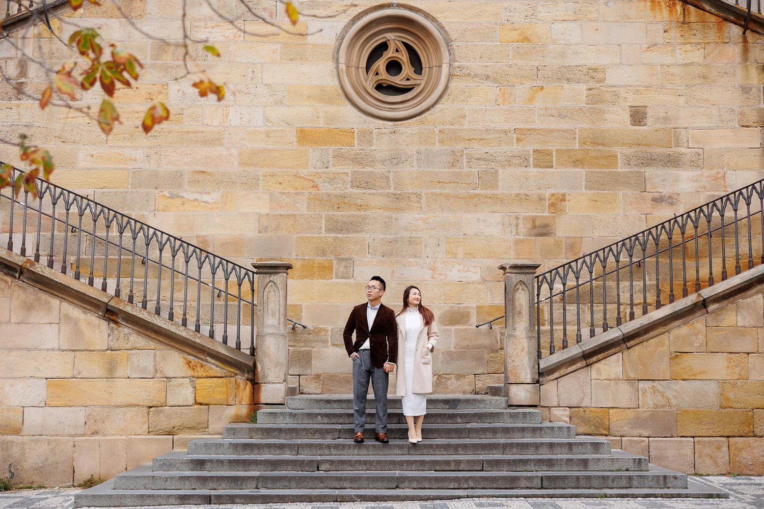 Couple on a wide stone staircase in Prague