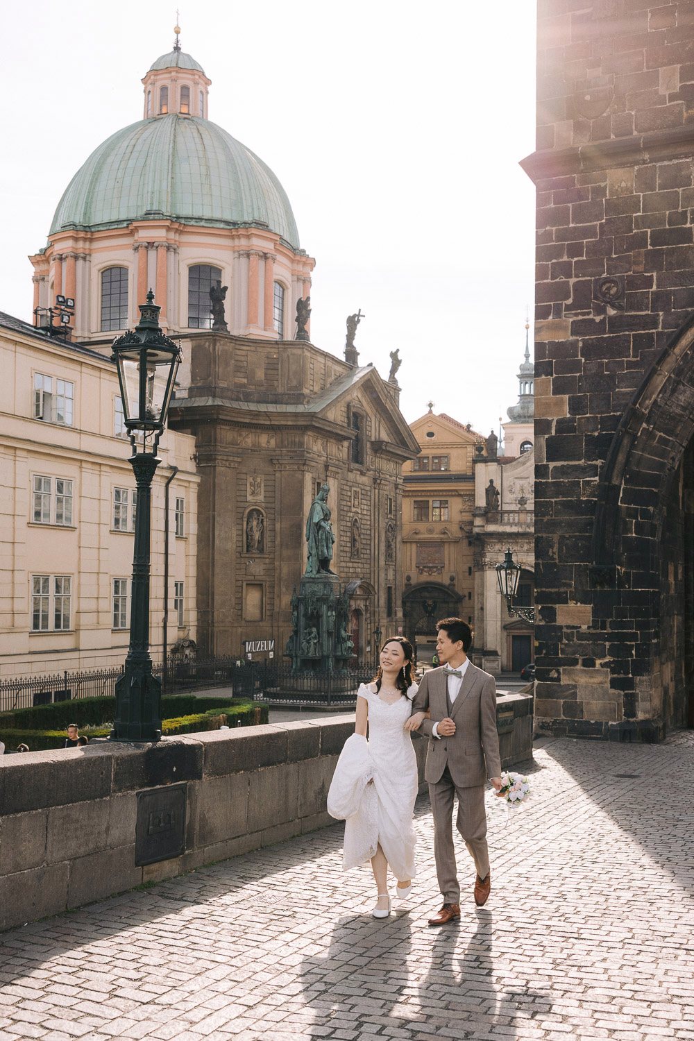Couple walking in Knights of the Cross Square by Charles Bridge