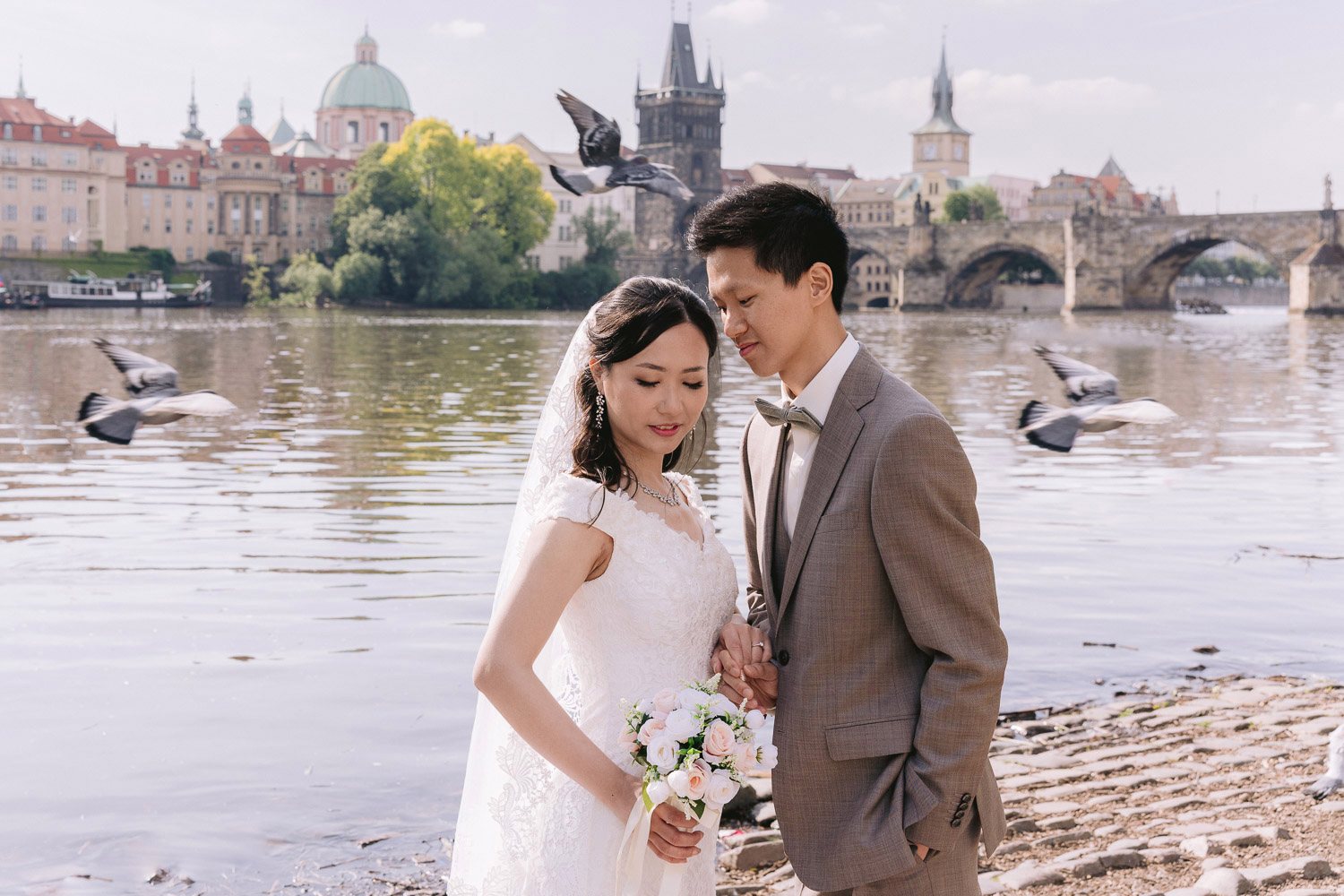 Couple by the Vltava with Charles Bridge and seagulls