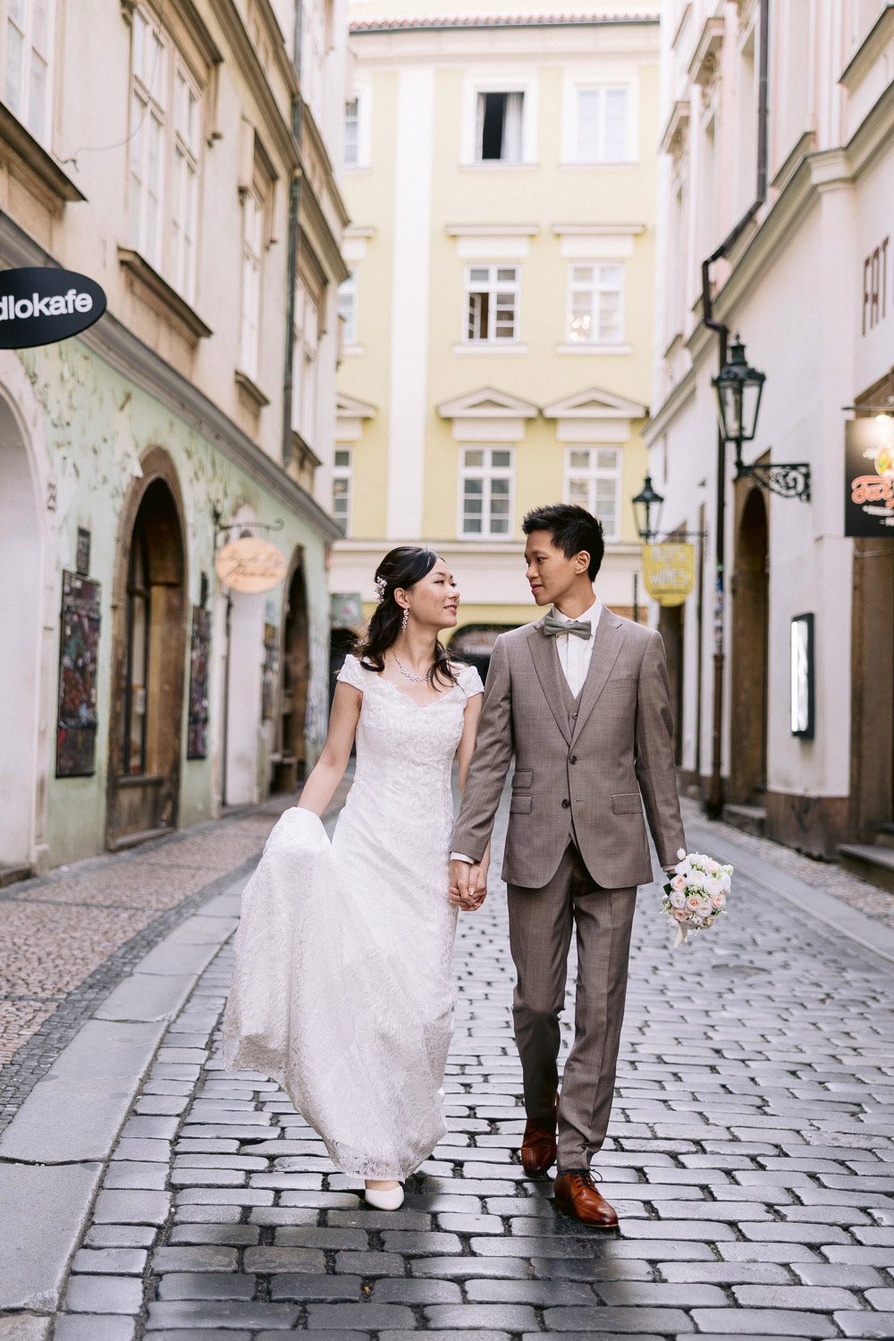 Bride and groom walking through a cobbled Old Town lane
