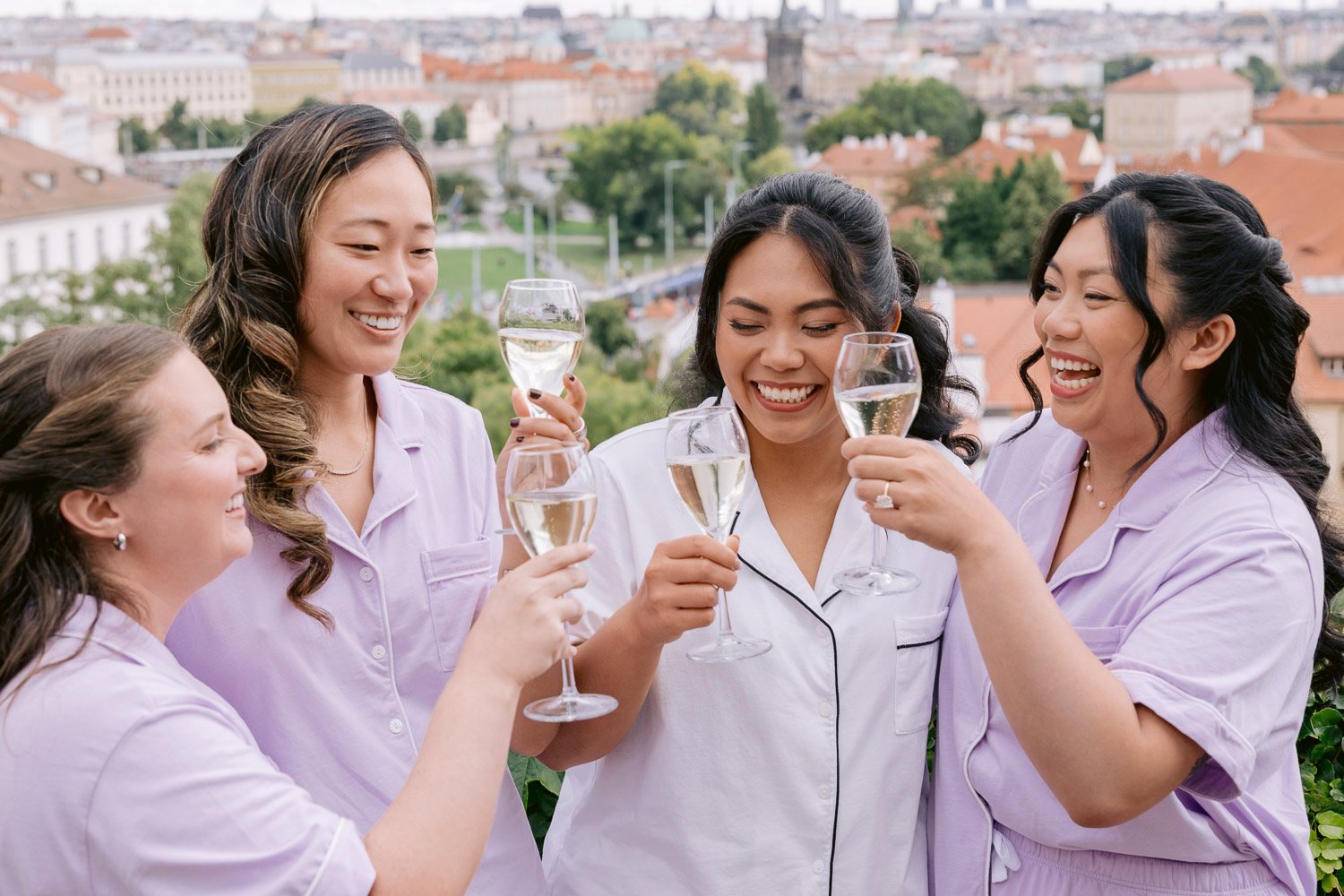 Villa Richter Bride Bridesmaids Toast Prague View Bride and bridesmaids in matching pyjamas toasting with Prague behind them