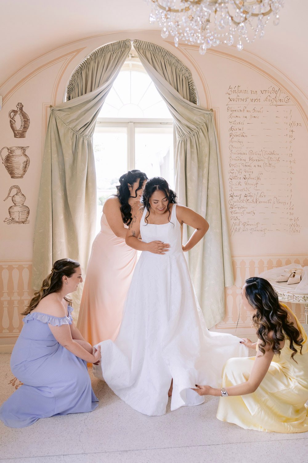 Villa Richter Bridesmaids Help Bride Into Dress Bridesmaids helping the bride into her dress