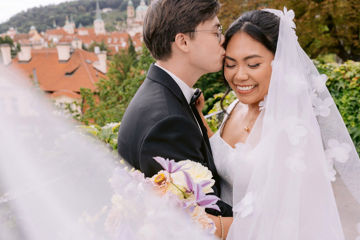 Villa Richter Wedding Kiss Veil Prague View Bride and groom kissing under her veil on the Villa Richter terrace with Prague behind them